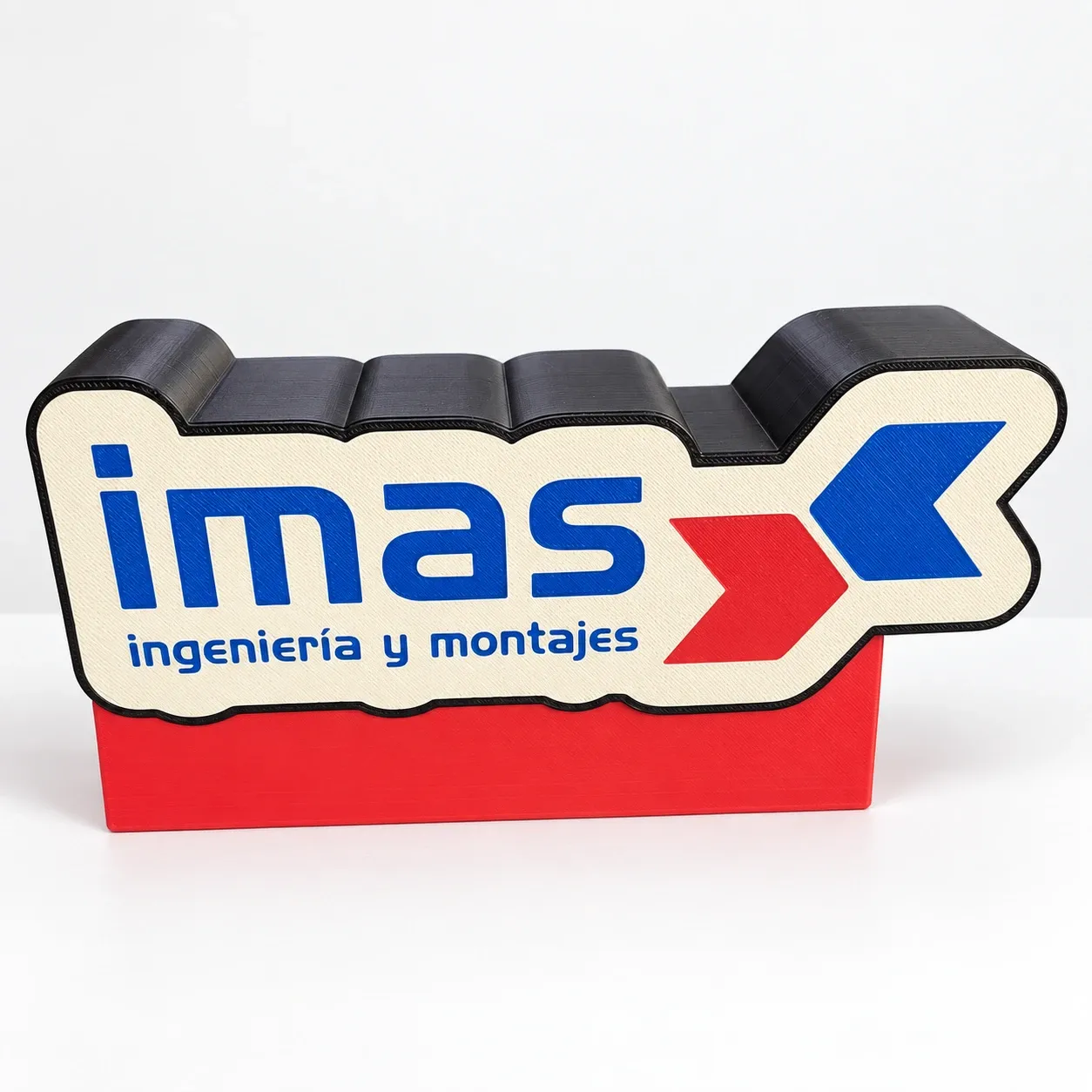 Cartel luminoso con el logo de la empresa IMAS Ingeniería y Montajes en azul y rojo sobre base roja, impreso en 3D