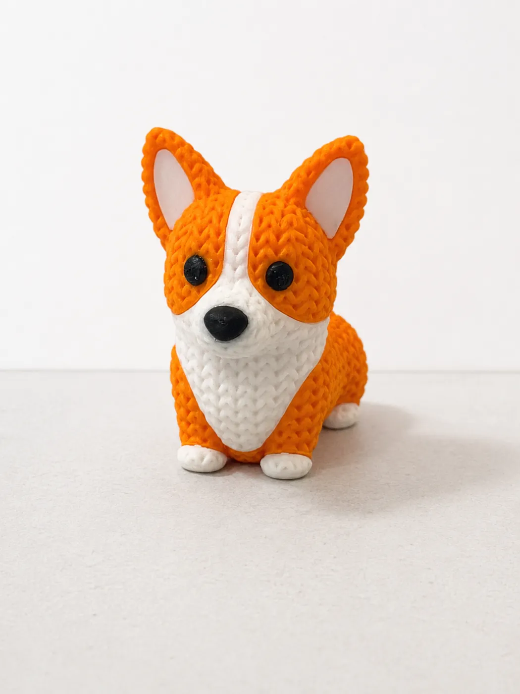 Figura de perro corgi con textura de crochet impresa en 3D en naranja y blanco