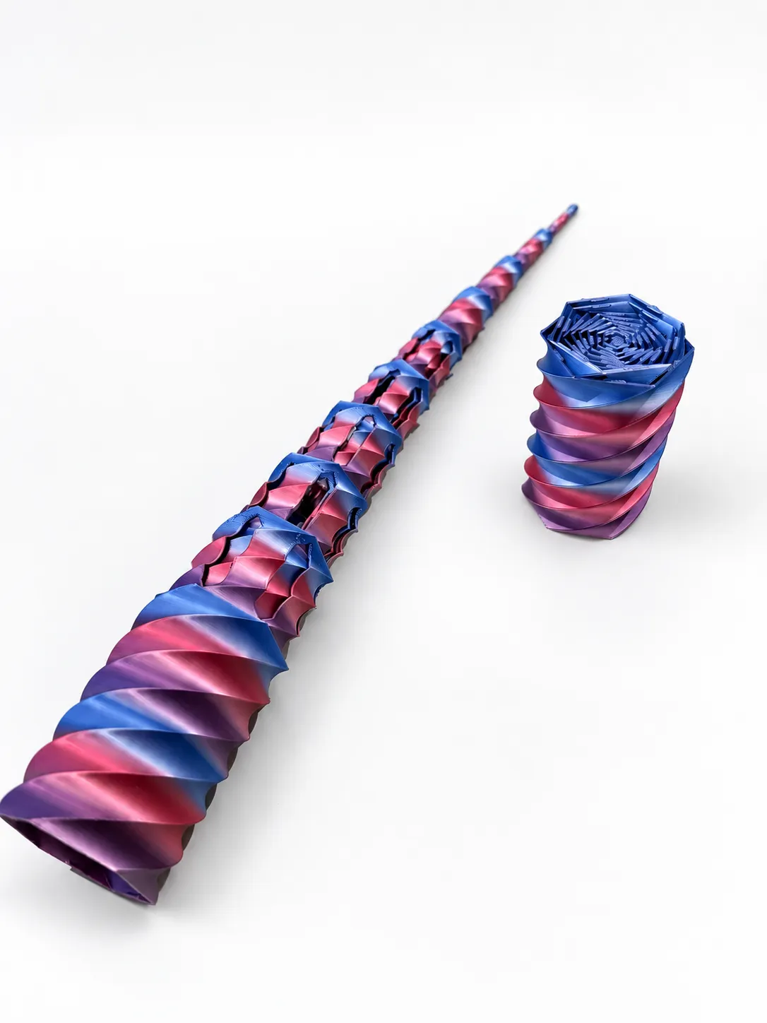 Juguete sensorial telescópico que se estira y se recoge, impreso en 3D en azul y rosa