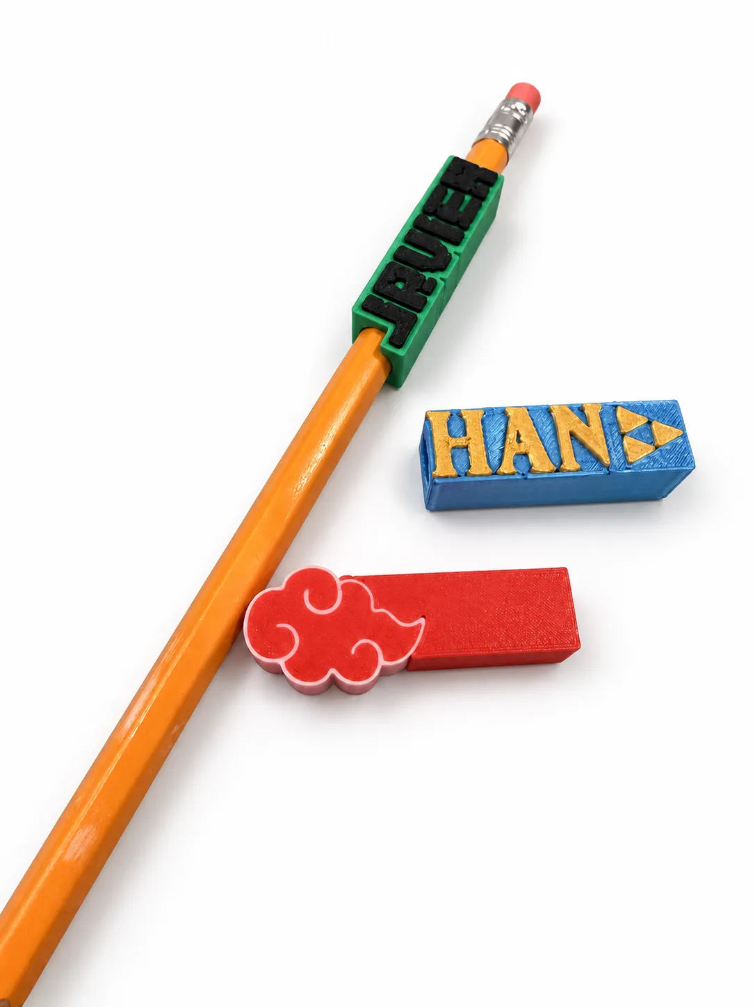 Toppers de lápiz personalizados con el nombre Javier, el nombre Han con la trifuerza de Zelda y la nube Akatsuki de Naruto impresos en 3D